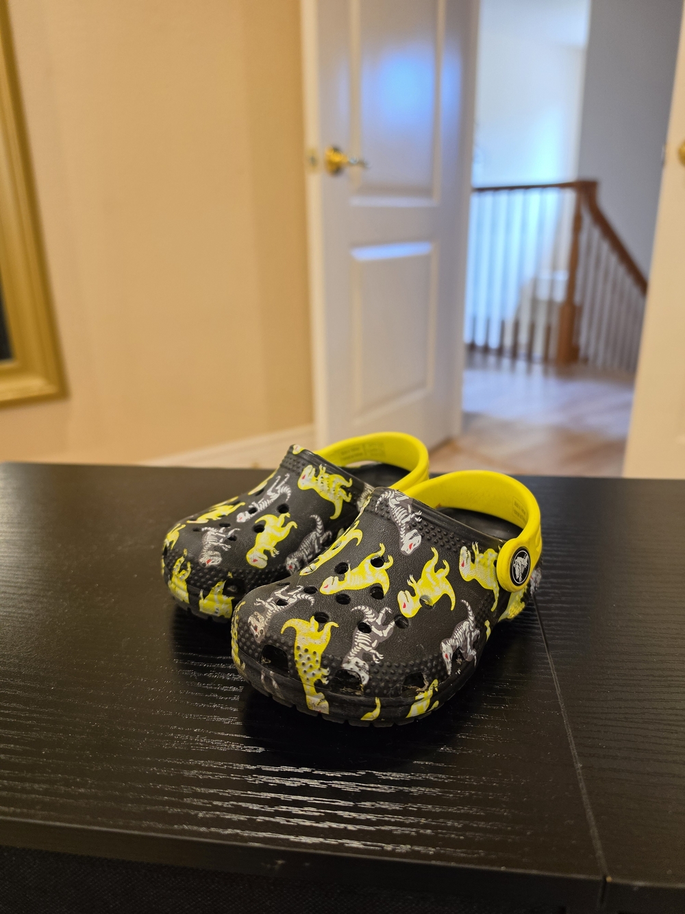 CROCS Black Clogs with Bright Yellow Dinosaur Accents